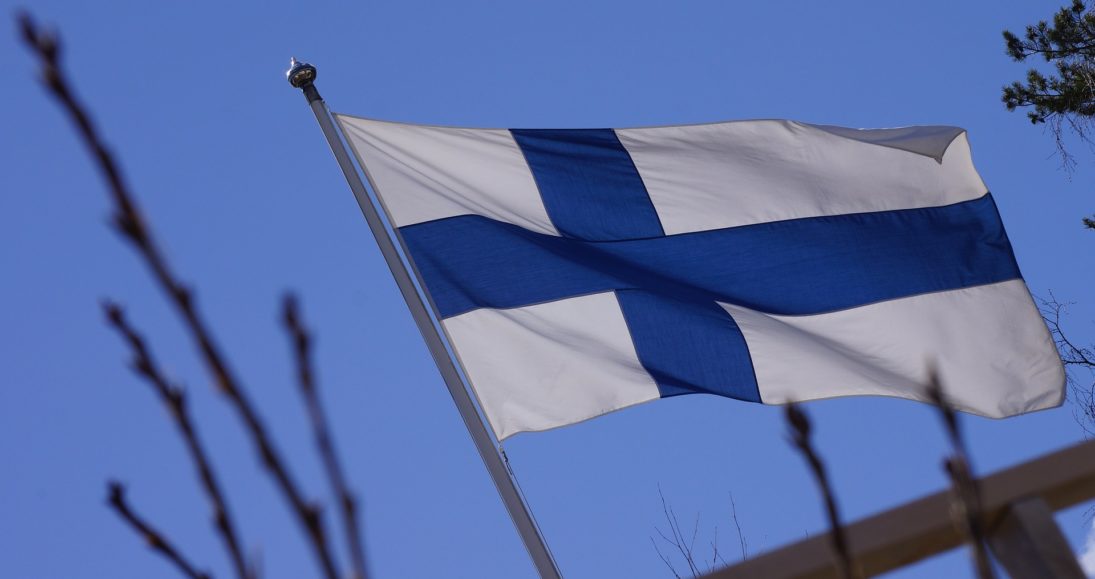 Suomen lippu lähikuvassa kirkasta taivasta vasten