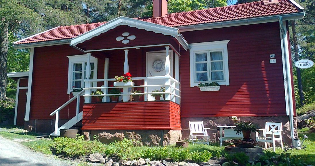 Taiteilija Annette Juuselan taiteilijakoti Tuiska. Punainen pieni idyllinen talo kesäisessä maisemassa.