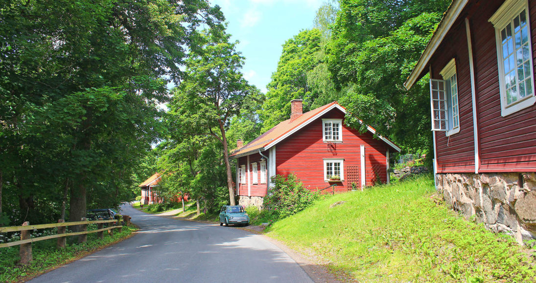 Kesäinen kuva Kauttuan Ruukinpuiston Sepäntiestä. Oikealla punamullattuja asuintaloja 1800-luvulta.